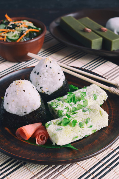 混合日本食物-饭团饭团，煎蛋卷，生姜，日式裙带菜黄瓜沙拉。传统的豆和绿茶抹茶甜品-果冻洋芋，大福麻糬