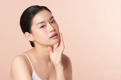美丽的年轻亚洲女人与干净新鲜的皮肤米色背景，面部护理，面部治疗，美容，美容和水疗，亚洲女性肖像。