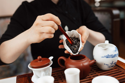 中国茶道。女孩把茶叶倒进茶壶里