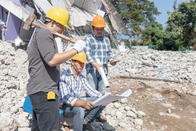 工程师建筑师和工人操作控制拆除旧建筑。