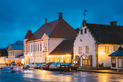 Kuressaare,爱沙尼亚。在塔林那街的市场附近的旧总重量储存大楼的晚上。街道在喜庆的圣诞圣诞新