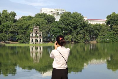一名年轻女子在河内用智能手机拍照