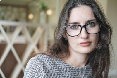 混血儿年轻女子的肖像看着相机。戴眼镜的中东妇女。淡定的黑发女人，长发戴眼镜。视力矫正，眼镜店，眼镜店