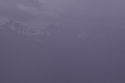 在一个凉爽的早晨，美丽的锯齿状白雪覆盖的山脉被极厚的雾包围的特写