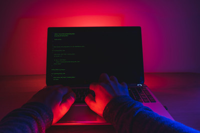 年轻勤奋的软件开发人员在晚上用手提电脑编码。