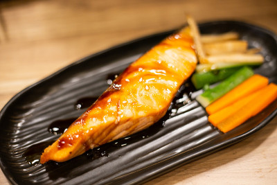 日式料理，黑色盘子上的烤鲑鱼