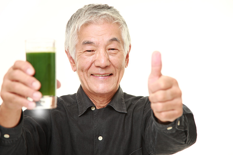 日本老男人和绿色蔬菜汁