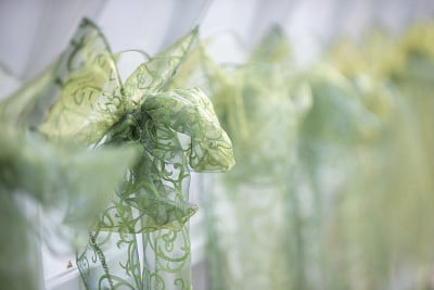 绿色的花边蝴蝶结和饰带垂在白色的椅子上