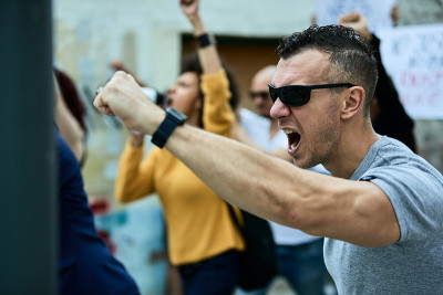 愤怒的白人男子举起拳头抗议人权。