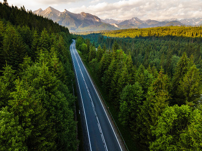 在森林的道路进入荒野和山脉无人机的视图
