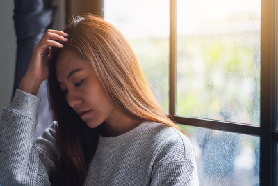一个悲伤和紧张的年轻亚洲女人独自坐着