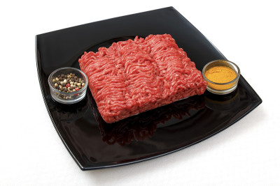 黑色盘子里放着新鲜牛肉和香料