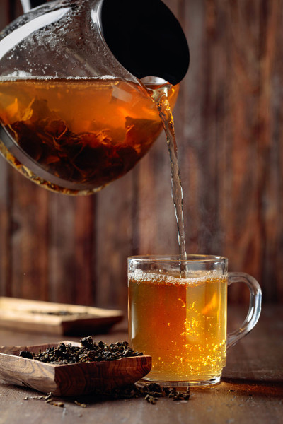 将新鲜的绿茶从茶壶倒入杯中。