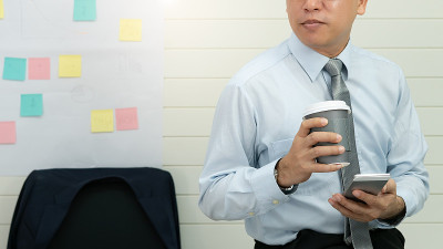 专业的商务人士手持在纸杯玻璃杯中喝新鲜的咖啡早上清爽的咖啡休息前工作会议电脑智能手机手机
