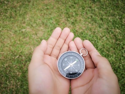 拿着罗盘显示你的方向和导航指向北方。