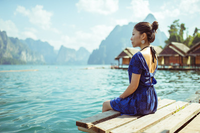 穿蓝色衣服的女孩坐在湖边