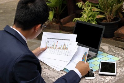 英俊的商人看着文件图表想着他的工作