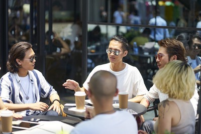 年轻的亚洲成年人在户外咖啡店放松