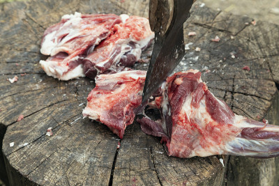 用斧头砍树桩上的肉。