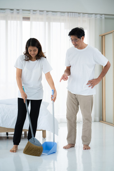 一对亚洲老夫妇正在打扫卧室地板。
