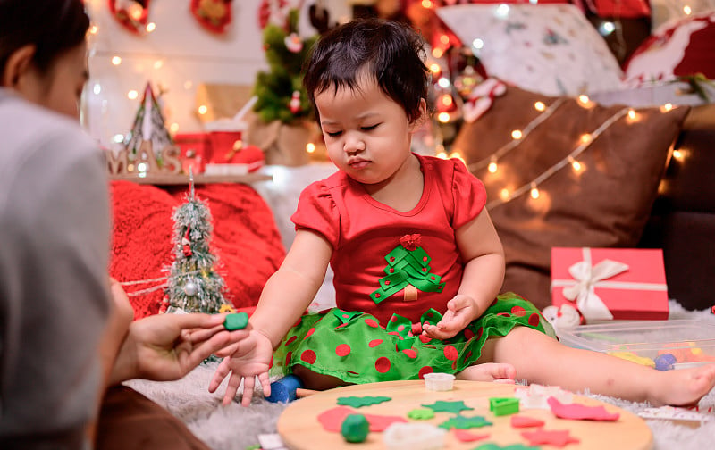 家人在家里庆祝圣诞节和新年快乐。妈妈和孩子的生活方式在年底的季节假期。