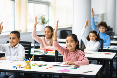 在教室里举手的小学生的不同群体
