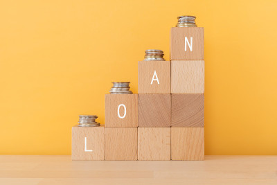 木块上有“LOAN”文字的概念和钱币。