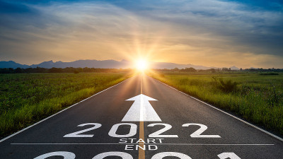 2022年新年或开始直观。字2022和策略写在夕阳下的柏油路上。目标和挑战或职业道路的概念，成功的业