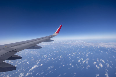 从窗口看飞机机翼，美丽的天空。旅游的概念