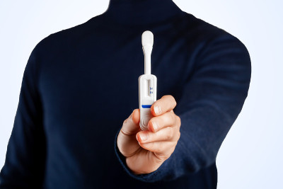 蓝色背景上的男子拿着口腔HIV检测结果。