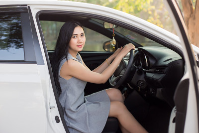 可爱的年轻女士快乐驾驶汽车