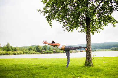 virabhadrasana。瑜伽女孩训练户外自然背景。瑜伽的概念。