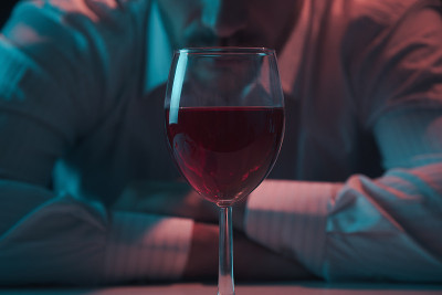 来杯红酒。一个男人靠在一杯酒上。