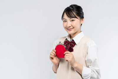 亚洲女学生拿着一个硬币钱包。