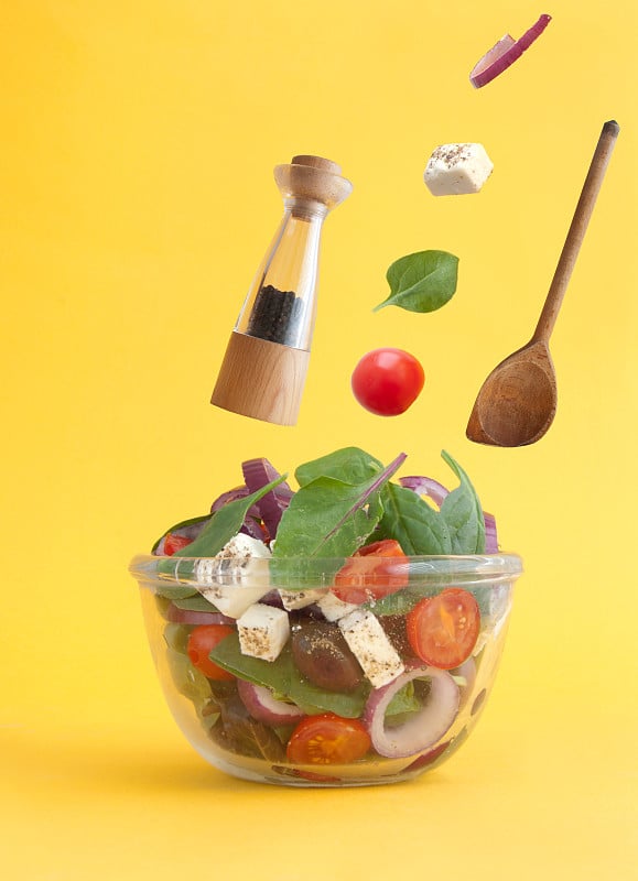 Salad ingredients falling into bowl