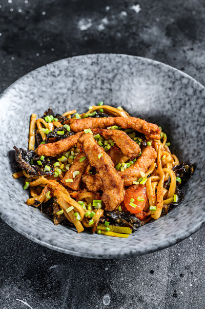 乌冬椒鸡肉面。黑色背景。俯视图