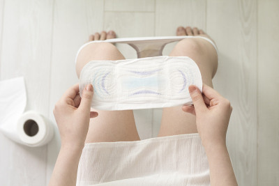 在厕所里拿着白色卫生巾的女人