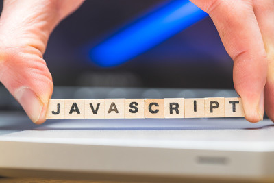 Javascript编程网络语言:在笔记本电脑上放置一个带有字母“Javascript”的木制立方体