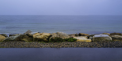 在科德角法尔茅斯的阳光自行车道的岩石肩膀上的雨天海景