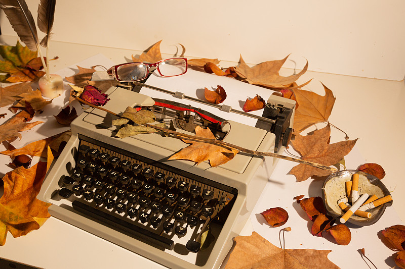 Top view of man's hands on a typewriter with autum