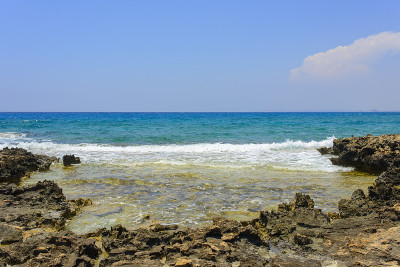 塞浦路斯阿伊纳帕海岸的黑色和黄色的岩石、石头和蓝色的大海