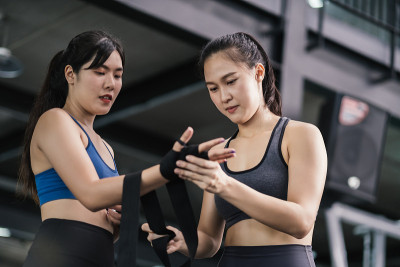 年轻的亚洲女子体育训练拳击手准备带腕上教练教练，拳击练习运动的战斗或与一个伙伴在健身馆锻炼健康的生活