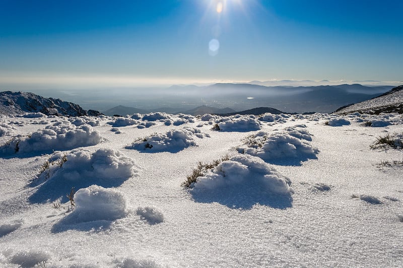 在博拉德尔蒙多的雪景日落。冰雪，在山的地平线，和云海。瓜达拉玛山脉国家公园，纳瓦克拉达，西班牙马德里