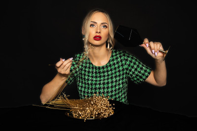 新娘金饮食豪华年轻的金发女人在黑色背景的绿色衣服是无聊的饮食。进食障碍的概念。影棚拍摄