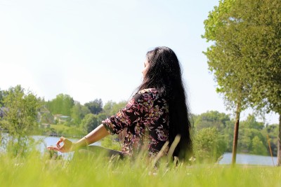 年轻迷人的女子在公共公园旁边的水盘做瑜伽练习