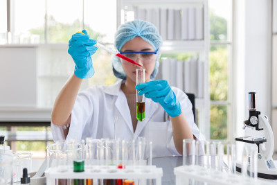 亚洲女科学家们戴着发网、眼镜和手套，在实验室里进行科学实验和细菌分析。女专家。实验室研究人员