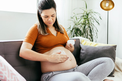 孕妇在腹部涂护肤化妆品。