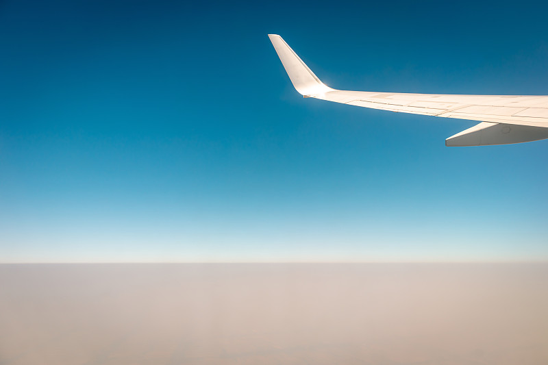 日落时飞机在云层上空飞行