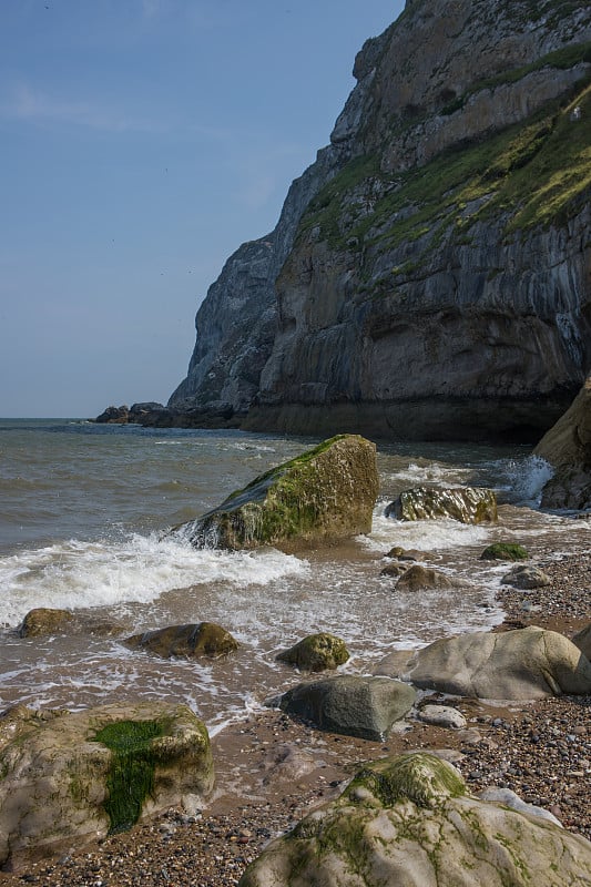 海浪拍打着小奥姆的岩石，Llandudno。北威尔士卵石滩