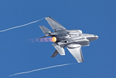 F-35闪电II在一个高g机动，加力燃烧器和凝结尾在机翼的尖端